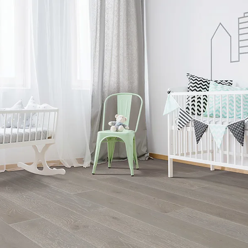 Nursery with grey hardwood flooring
