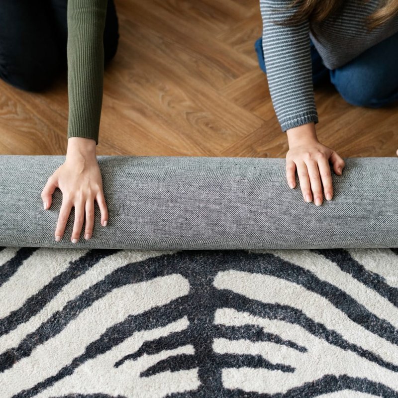 Rolling up an animal print area rug