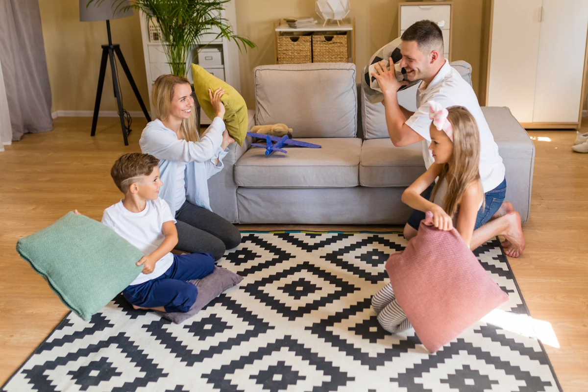 Family playing on a patterned area rug